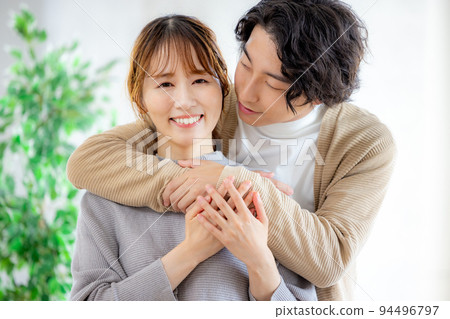 Young couple cuddling with a smile 94496797