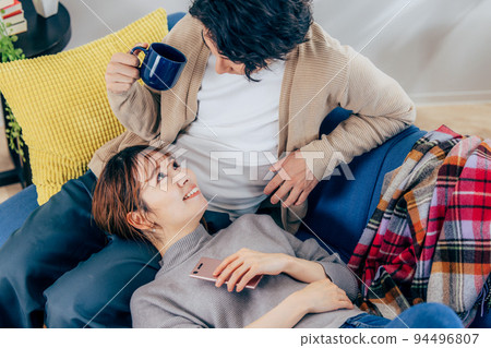 放鬆在客廳的一對年輕夫婦 94496807