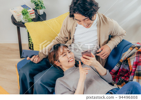 放鬆在客廳的一對年輕夫婦 94496808