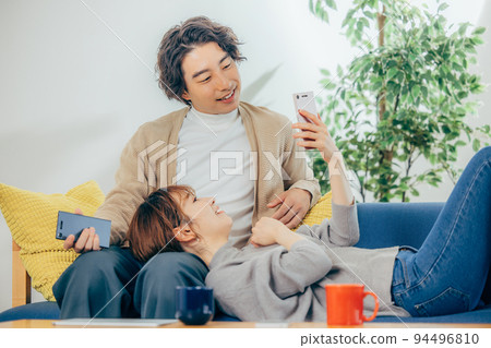 放鬆在客廳的一對年輕夫婦 94496810