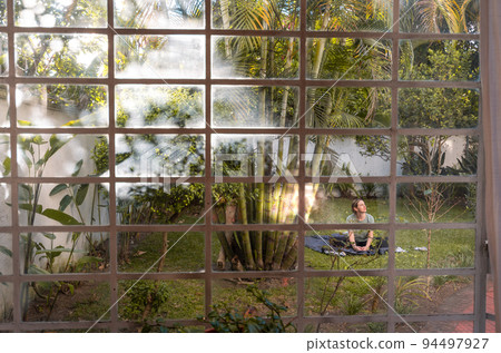 Girl doing yoga in the backyard of the house 94497927