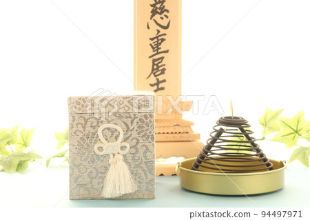 An urn for a memorial service and a portrait of the deceased placed by the window. An urn for a memorial service and a portrait of the deceased placed by the window. 94497971