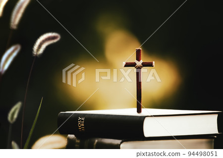 The sunset scenery, the Bible, the bright light and the holy cross of Jesus Christ 94498051
