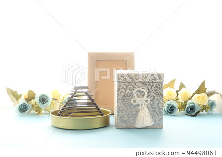 An urn for a memorial service and a portrait of the deceased placed by the window. An urn for a memorial service and a portrait of the deceased placed by the window. 94498061