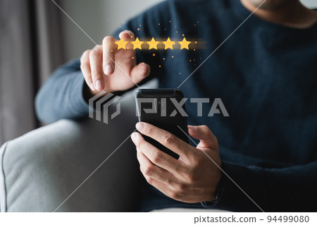 Close up of man customer giving a five star rating on smartphone. Review, Service rating, satisfaction, Customer service experience and satisfaction survey concept.. 94499080