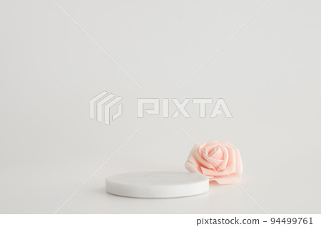 White marble podium on the white background with pink flowers. Podium for product, cosmetic presentation. Creative mock up. Pedestal or platform for beauty products. 94499761