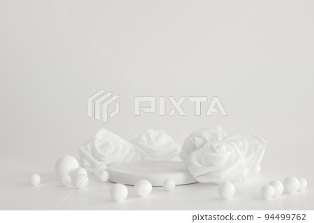 White marble podium on the white background with pearls and flowers. Podium for product, cosmetic presentation. Creative mock up. Pedestal or platform for beauty products. 94499762