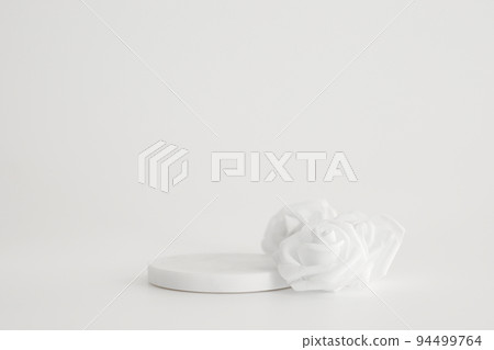 White marble podium on the white background with flowers. Podium for product, cosmetic presentation. Creative mock up. Pedestal or platform for beauty products. 94499764
