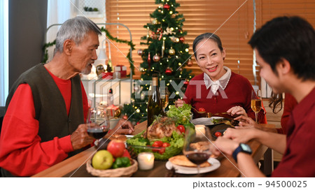 Image of happy family celebrating Christmas together at home lighted with soft lights and candles. Celebration, holidays and people concept Image of happy family celebrating Christmas together at home lighted with soft lights and candles. Celebration, holidays and people concept 94500025