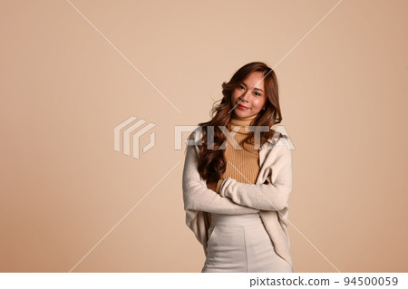 Beautiful fashionable woman in autumn outfit posing on beige background. Fashion studio photo, Autumn fashion and beauty concept Beautiful fashionable woman in autumn outfit posing on beige background. Fashion studio photo, Autumn fashion and beauty concept 94500059