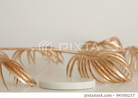 Marble podium with golden leaves on the white background. Podium for product, cosmetic presentation. Creative mock up. Pedestal or platform for beauty products. 94500237