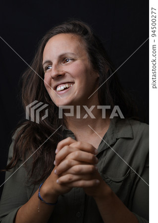 Cheerful happy young beautiful girl smiling laughing over black background. Close-up portrait of pretty young woman. 94500277
