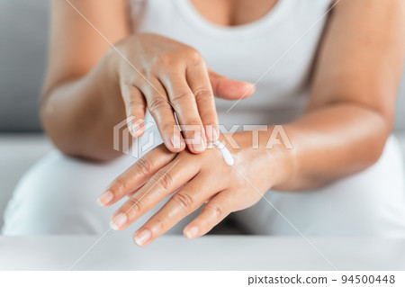 Woman applying body lotion moisturizer on her hands. Woman applying body lotion moisturizer on her hands. 94500448