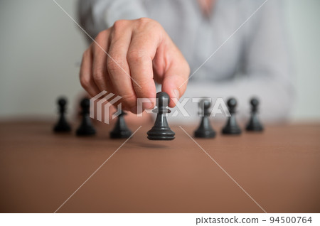 Closeup view of caucasian male hand moving a pawn chess piece 94500764
