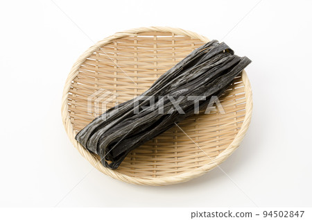 Dried kelp placed on a bamboo basket with a white background Dried kelp placed on a bamboo basket with a white background 94502847