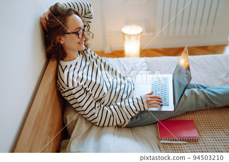 Young female freelancer works and makes notes while working at home in quarantine lockdown. Freelancer. 94503210