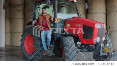 Young man farmer in tractor with open door and smiling to camera. Agriculture farming. Young man farmer in tractor with open door and smiling to camera. Agriculture farming. 94503238