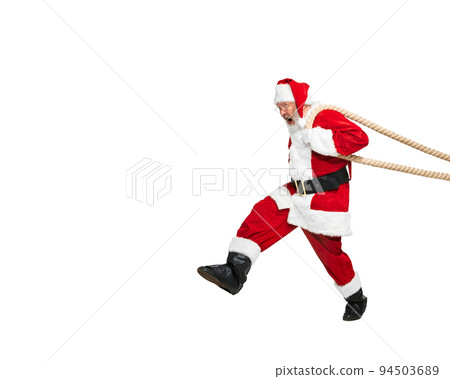 Portrait of emotive senior man in image of Santa Claus pulling something with rope isolated over white background 94503689