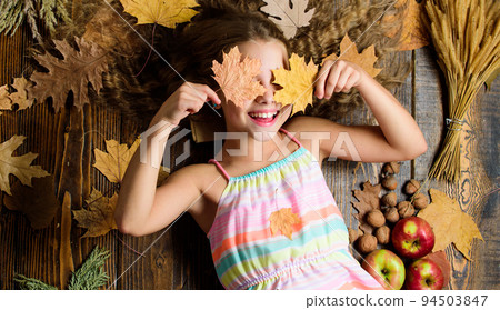 Coziest things about fall. Kid cute girl relax wooden background autumn attributes top view. Child long hair with dry leaves. Tips for turning autumn into best season. Autumn coziness is just around 94503847