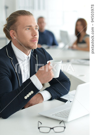 Portrait of a smiling business man using a laptop. Portrait of a smiling business man using a laptop. 94503978