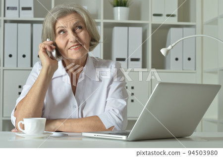 Elderly woman in headphones take online course on computer at home. Elderly woman in headphones take online course on computer at home. 94503980