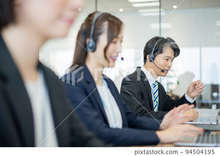 在呼叫中心工作的穿西裝的中間人 在呼叫中心工作的穿西裝的中間人 94504195