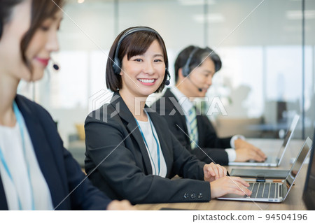 Smiling young woman working in a call center Smiling young woman working in a call center 94504196