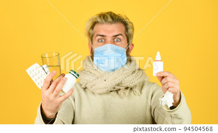 Pharmacy concept. Lot of medicines. Prevention concept. Man sick leave at home. Bearded guy messy hair wear mask hold pills tablets vitamins medicines in hands. Medicines effective treatment Pharmacy concept. Lot of medicines. Prevention concept. Man sick leave at home. Bearded guy messy hair wear mask hold pills tablets vitamins medicines in hands. Medicines effective treatment 94504568