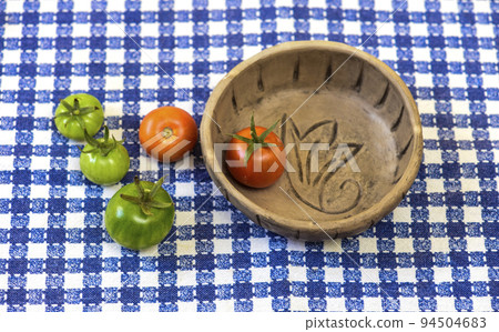 Green and red tomatoes on the table 94504683