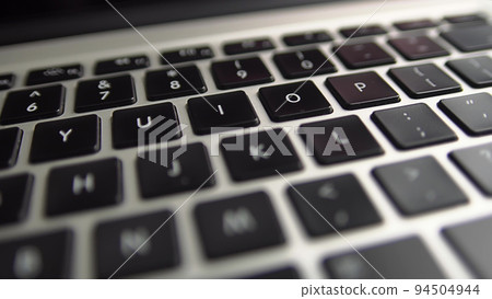 Close-up macro panoramic view of keyboard on the laptop computer. Slow macro soft focus dolly shot. 94504944