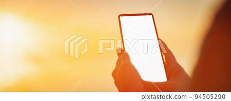 Woman hands holding smartphone at outdorrs in the evening 94505290