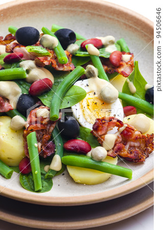 salad of green and red beans with black olives, spinach, boiled egg and bacon 94506646