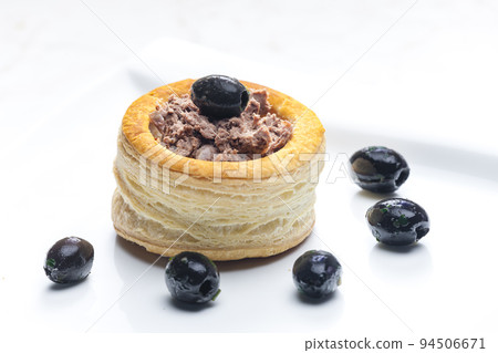 puff pastry filled with terrine served with black olives 94506671