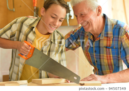 Senior carpenter and his grandson in the workshop 94507349