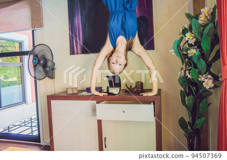 A woman is standing on his hands upside down in the living room 94507369
