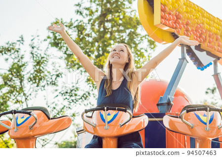 Beautiful, young woman having fun at an amusement park 94507463