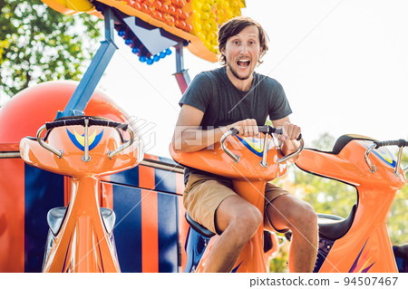Beautiful, young man having fun at an amusement park 94507467