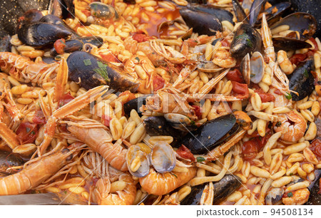 Italian Cavatelli allo scoglio, pasta with seafood and tomatoes close up in a frying pan 94508134