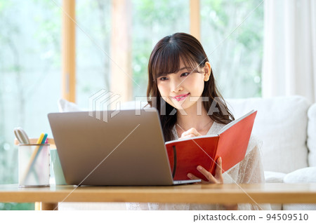 年輕女子在客廳裡做遠程辦公 年輕女子在客廳裡做遠程辦公 94509510