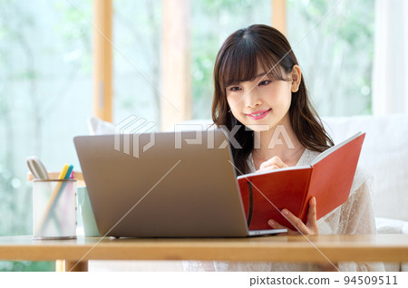 Young woman doing telework in the living room Young woman doing telework in the living room 94509511