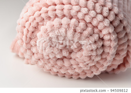 Roll up soft pastel pink fleece throw fabric with lines. White background, copy space 94509812