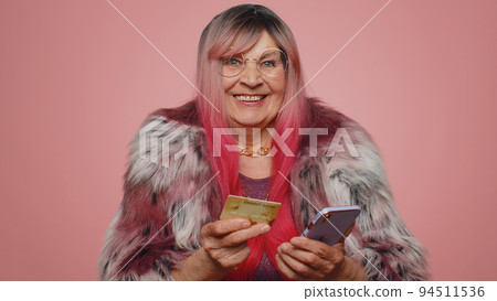 Senior woman using credit bank card smartphone while transferring money, purchases online shopping 94511536