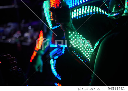 dancers in led suits on dark background, colored show. dancers in led suits on dark background, colored show. 94511681