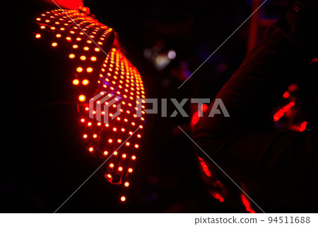 dancers in led suits on dark background, colored show. dancers in led suits on dark background, colored show. 94511688