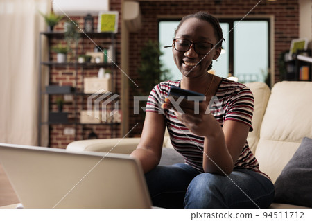 Woman holding credit card, making purchase in internet store, online payment, electronic shopping concept. Smiling person buying products using laptop, buyer paying for order 94511712