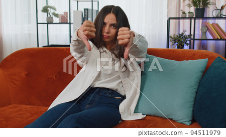 Upset young woman showing thumbs down, dislike bad work, disapproval, dissatisfied feedback at home Upset young woman showing thumbs down, dislike bad work, disapproval, dissatisfied feedback at home 94511979
