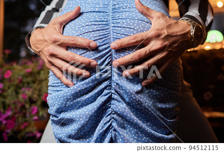 Close up of a man's hand touching a woman's butt. 94512115