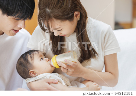 一對夫婦給嬰兒牛奶 94512191