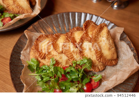 hot homemade pasties on a wooden board copy space. 94512446