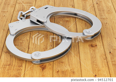 Handcuffs on the wooden table, 3D rendering 94512701